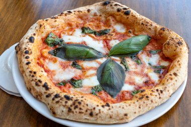 Ekşi hamurlu düz ekmek mozzarella peyniri, domates ve fesleğen yapraklı Margarita, Napoli sokak yemeği, İtalya, kapatın.