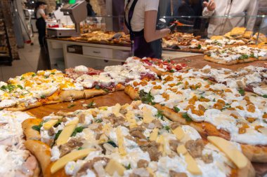 Parma, Emilia Romanya, İtalya 'daki fırında sebzeli, biberli, mantarlı, domatesli ve peynirli taze Focaccia veya pala romana pizzası sokak kafesinde sergileniyor