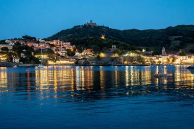 Deniz koyundaki gece manzarası, Collioure 'un eski kasabasının ışıkları ve renkli evleri, Cote Vermeille, Pyrenees-Orientales, Occitania, Fransa. Yaz hedefi