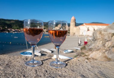 Eski Collioure kasabası manzaralı iki bardak gül Collioure AOC şarabı, renkli evler, kilise, kale ve plajlar, Occitanie, Fransa, turist beldesi