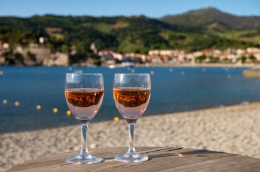 Eski Collioure kasabası manzaralı iki bardak gül Collioure AOC şarabı, renkli evler, kilise, kale ve plajlar, Occitanie, Fransa, turist beldesi