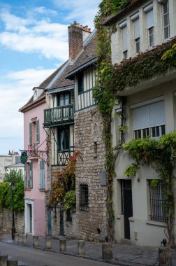 Paris 'in Montmartre dağlık tarihi sanatsal bölgesinde yürüyorum. Ünlü binalar ve yağmurlu sonbahar günlerinde dar sokaklar, Fransa' da turistlerin gideceği yer.