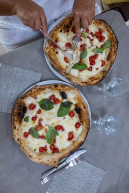 İtalyan pizzacıda fırın fırını, fırın, pizza ve pizza yemek. Kapatın.