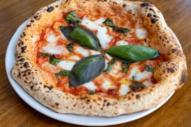 Ekşi hamurlu düz ekmek mozzarella peyniri, domates ve fesleğen yapraklı Margarita, Napoli sokak yemeği, İtalya, kapatın.