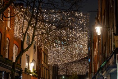 Londra 'nın tarihi caddelerinde yürürken Covent Garden' da Noel ışıklandırması ve çelenklerle süslenmiş yeşil Noel ağaçları ile, Aralık tatillerinde İngiltere 'de