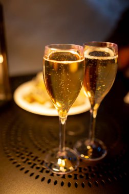 Two glasses of french sparkling wine champagne with little bubbles, New Year celebration, wedding or champagne tour with visit of caves, Reims, France, dark theme