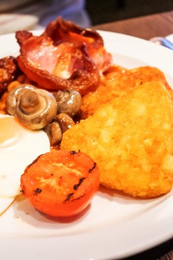 Yumurtalı tam İngiliz kahvaltısı, kızarmış pastırma, sosis, fasulye, tost, mantar, ızgara domates, klasik yemek, geleneksel İngiliz sabah yemeği.