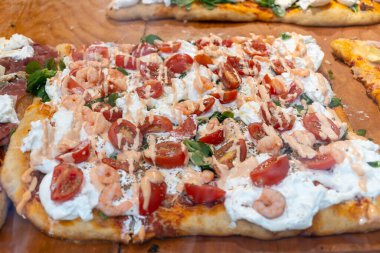 Parma, Emilia Romanya, İtalya 'daki fırında sebzeli, biberli, mantarlı, domatesli ve peynirli taze Focaccia veya pala romana pizzası sokak kafesinde sergileniyor