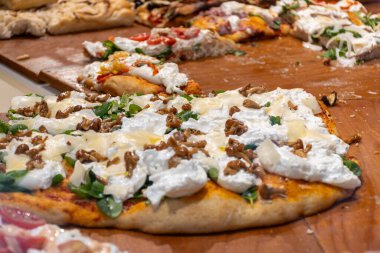 Parma, Emilia Romanya, İtalya 'daki fırında sebzeli, biberli, mantarlı, domatesli ve peynirli taze Focaccia veya pala romana pizzası sokak kafesinde sergileniyor
