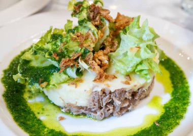 Şekerli ördek, patates püresi ve taze yeşil pesto karışımı Fransız yemeği Paris 'teki geleneksel bistro restoranında servis edilir.