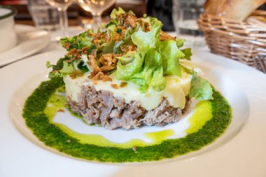 Şekerli ördek, patates püresi ve taze yeşil pesto karışımı Fransız yemeği Paris 'teki geleneksel bistro restoranında servis edilir.
