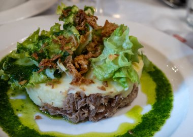 Şekerli ördek, patates püresi ve taze yeşil pesto karışımı Fransız yemeği Paris 'teki geleneksel bistro restoranında servis edilir.