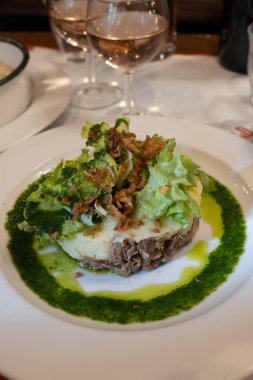 Şekerli ördek, patates püresi ve taze yeşil pesto karışımı Fransız yemeği Paris 'teki geleneksel bistro restoranında servis edilir.