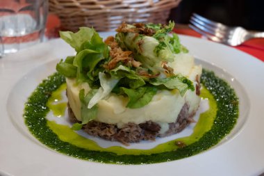 Şekerli ördek, patates püresi ve taze yeşil pesto karışımı Fransız yemeği Paris 'teki geleneksel bistro restoranında servis edilir.