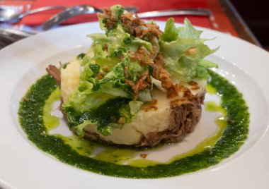 Şekerli ördek, patates püresi ve taze yeşil pesto karışımı Fransız yemeği Paris 'teki geleneksel bistro restoranında servis edilir.