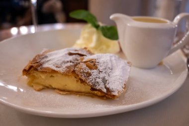 Viyana 'da bir kafede vanilya sosuyla servis edilen elmalı turta, Avusturya, Viyana' da tatlı tatlılar yemek.