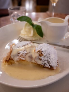 Viyana 'da bir kafede vanilya sosuyla servis edilen elmalı turta, Avusturya, Viyana' da tatlı tatlılar yemek.