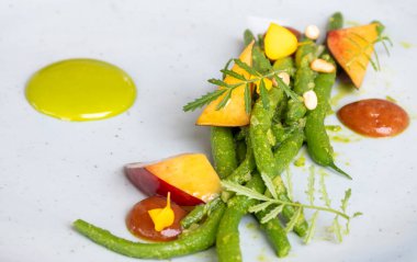 Fransız restoranında şefle güzel bir yemek, başlangıç vejetaryen yemeği ızgara taze fasulye ve taze nektarinler.