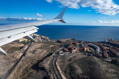 Uçak kanadı, Tenerife 'nin güneyindeki evler ve okyanus manzarası, aitport' a iniş sırasında, Avrupa 'da hava ulaşımı