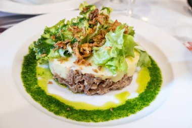 Şekerli ördek, patates püresi ve taze yeşil pesto karışımı Fransız yemeği Paris 'teki geleneksel bistro restoranında servis edilir.