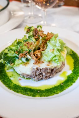 Şekerli ördek, patates püresi ve taze yeşil pesto karışımı Fransız yemeği Paris 'teki geleneksel bistro restoranında servis edilir.