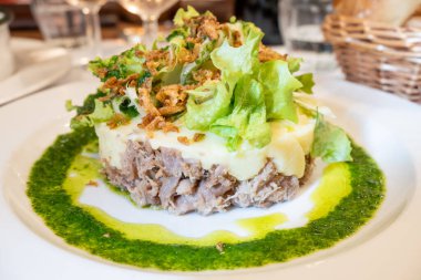 Şekerli ördek, patates püresi ve taze yeşil pesto karışımı Fransız yemeği Paris 'teki geleneksel bistro restoranında servis edilir.