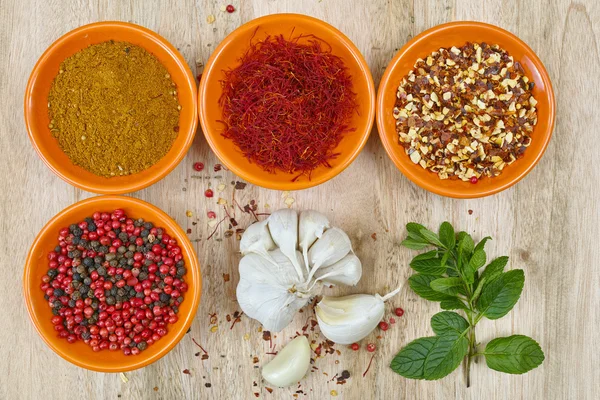 Fyra skålar med saffran, paprika, Ras El Hanout, färsk mynta och vitlök — Stockfoto