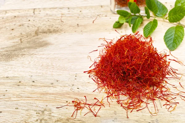 Safran rouge avec menthe fraîche sur plateau en bois de teck, espace de copie — Photo