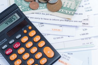 İpotek ve elektrik faturaları, sikke ve banknot, hesap makinesi