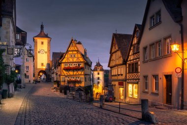 ROTHENBURG, GERMANY, 26 HAZİRAN, 2020: Ortaçağ 'ın Rothenburg ob der Tauber kasabasının klasik manzarası, akşam alacakaranlığı sırasında alacakaranlıkta, Bavyera, Almanya' da aydınlandı