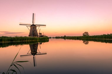 Hollanda 'daki Kinderdijk' in yel değirmenleri üzerinde inanılmaz bir gün batımı.