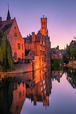 BRUGES, BELGIUM, 21 HAZİRAN 2020: Tarihi merkezdeki kanal üzerinde gün batımı
