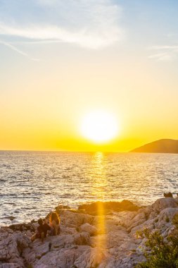 Hırvatistan 'ın Hvar Adası' nın kayalık plajında güzel bir gün batımı