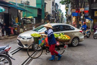 HANOI, VİETNAM, 4 HAZİRAN 2020: Tren sokağında geleneksel şapkalı bir kadın