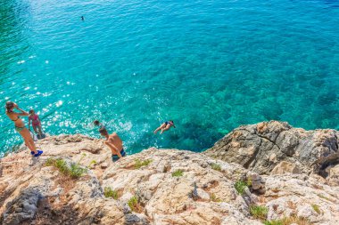 HVAR, CROATIA, AĞUSTOS 8 2019: Adriyatik Denizi 'nin Hvar Adası' ndaki Jagodna Sahili 'nin güzel ve kristal sularına dalan bir turist ailesi