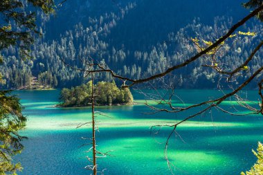 Güneş ışığı altında Zugspitze zirvesinin önündeki turkuaz suyla Eibsee Gölü 'nün muhteşem manzarası. Konum: Eibsee Gölü, Garmisch-Partenkirchen, Bavyera Alpleri, Almanya, Avrupa