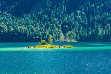 Güneş ışığı altında Zugspitze zirvesinin önündeki turkuaz suyla Eibsee Gölü 'nün muhteşem manzarası. Konum: Eibsee Gölü, Garmisch-Partenkirchen, Bavyera Alpleri, Almanya, Avrupa