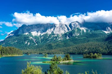 Güneş ışığı altında Zugspitze zirvesinin önündeki turkuaz suyla Eibsee Gölü 'nün muhteşem manzarası. Konum: Eibsee Gölü, Garmisch-Partenkirchen, Bavyera Alpleri, Almanya, Avrupa