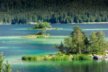 Güneş ışığı altında Zugspitze zirvesinin önündeki turkuaz suyla Eibsee Gölü 'nün muhteşem manzarası. Konum: Eibsee Gölü, Garmisch-Partenkirchen, Bavyera Alpleri, Almanya, Avrupa