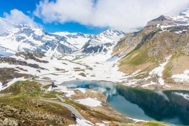Gran Paradiso Ulusal Parkı 'ndaki karlı arazide güzel zümrüt Alp Gölü