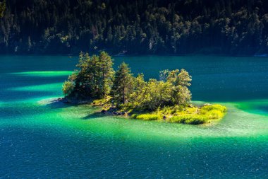 Güneş ışığı altında Zugspitze zirvesinin önündeki turkuaz suyla Eibsee Gölü 'nün muhteşem manzarası. Konum: Eibsee Gölü, Garmisch-Partenkirchen, Bavyera Alpleri, Almanya, Avrupa