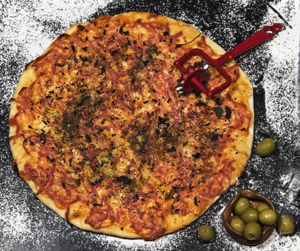 Pizza, kulatý nůž, olivový chutné na černém pozadí — Stock fotografie