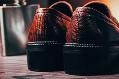 Yılan derisi ve köknar üzerinde paslanmaz şişesi mocasine (ayakkabı)