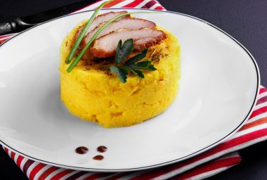 Pişmiş domuz Mısır Mash yatağa üç dilim zekâ dekore edilmiştir.