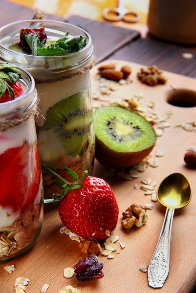 Zwei Gläser mit hausgemachten Haferflocken mit frischem Joghurt mit Kiwi und — Stockfoto