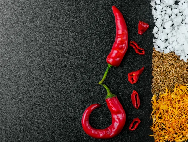 Two pepper chili and cutted chili.Stripe of sea salt, cumin and — Stock Photo, Image
