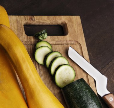 Bıçak ile ahşap mutfak masasında taze dilimlenmiş kabak. arka plan. closeup