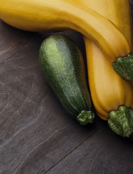 Two yellow big and medium  small green zucchini on wooden table.Family of zuccini.