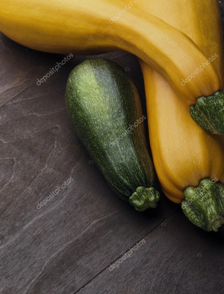 Two yellow big and medium small green zucchini on wooden table ... Two yellow big and medium small green zucchini on wooden table ...