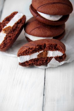 Kırık kurabiye ve kağıt üzerinde krema ile sünger çerezleri yığını. dikey çekim. Seçici odaklama